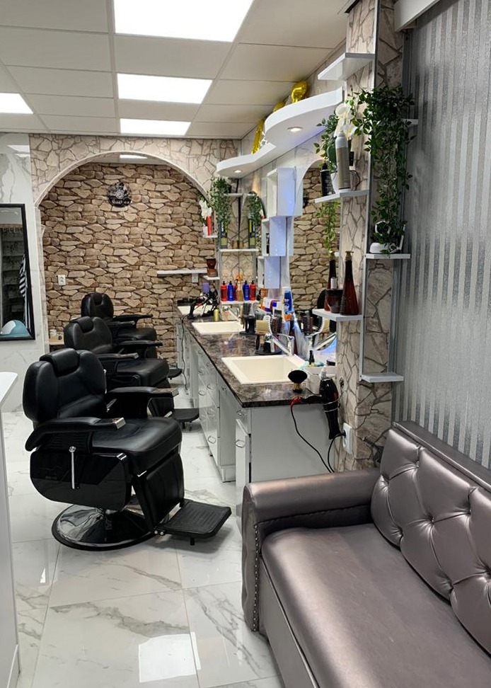 De kappersstoelen, spiegels en stenen achterwand in Dubai Barber